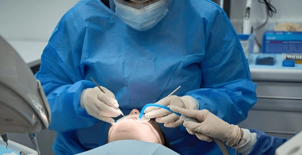 دستیار دندانپزشک در حال بررسی عملکرد ساکشن
